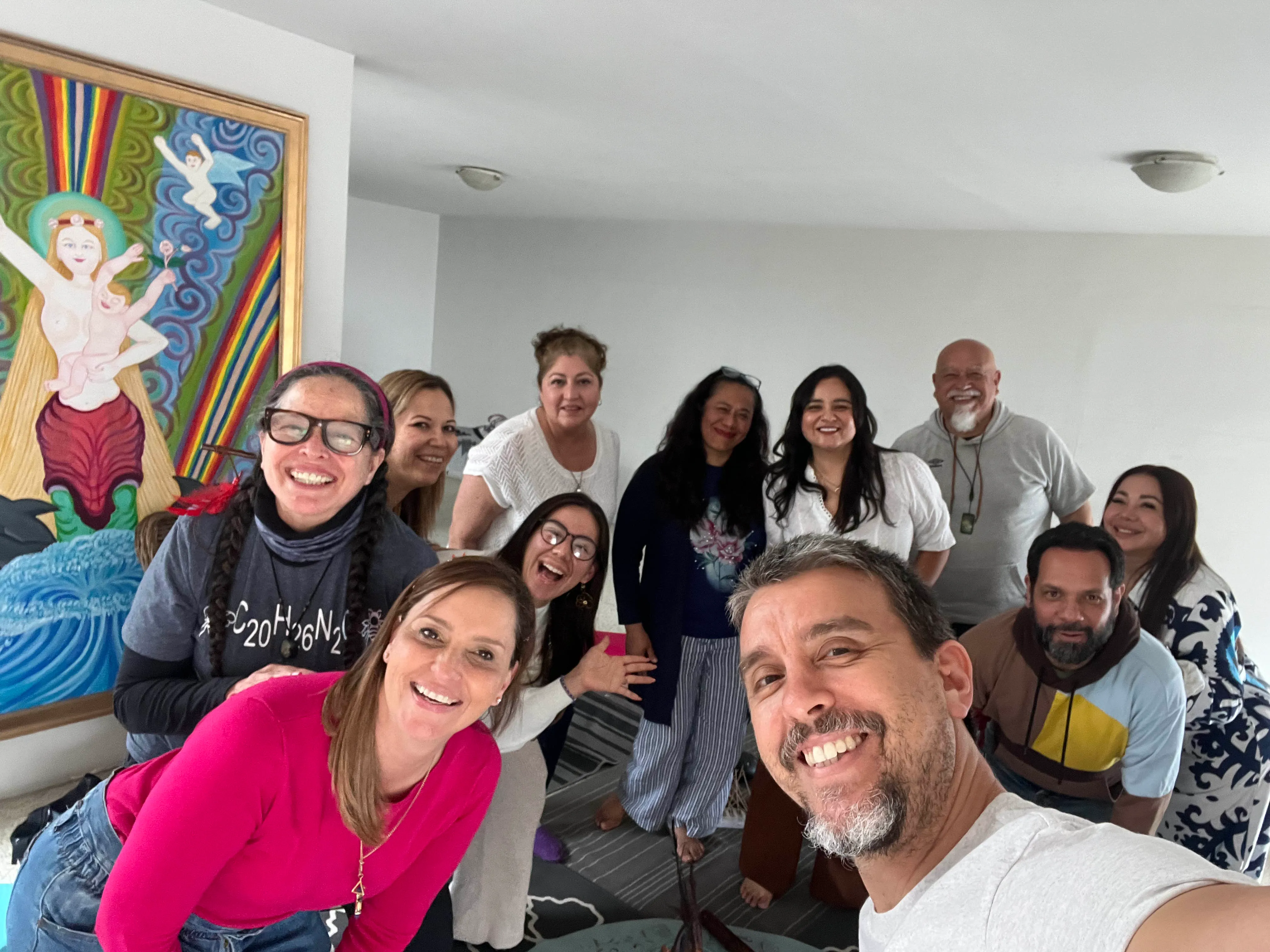 Carmen Villarreal y Matías Mahia con un grupo de alumnos dentro de La Casa Dakini en Tijuana, con la pintura tradicional de la Dakini de fondo
