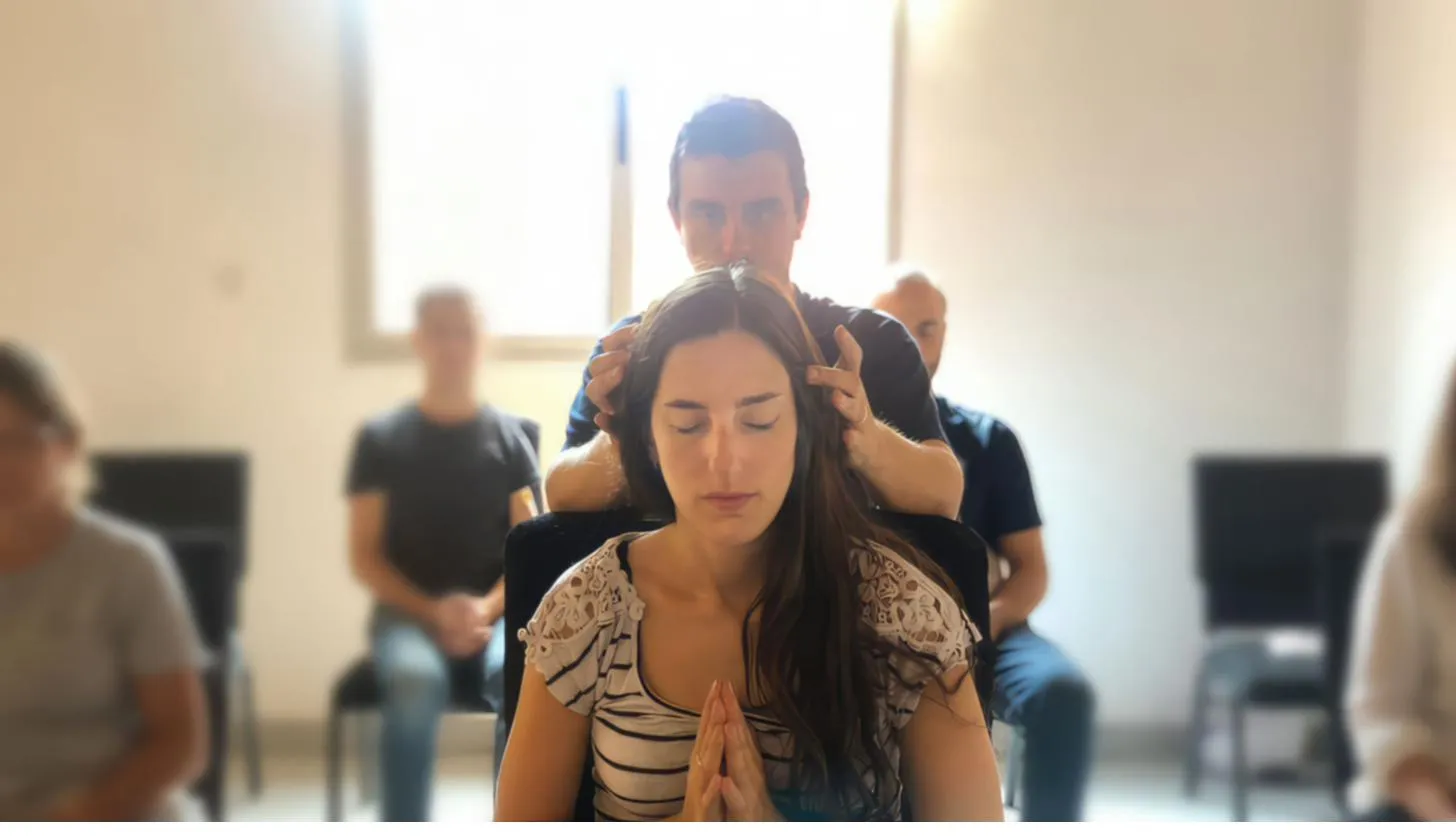 Matías Mahia haciendo una sintonización de Reiki —Reiju— a una alumna, con sus manos sobre la cabeza mientras ella recibe en namasté