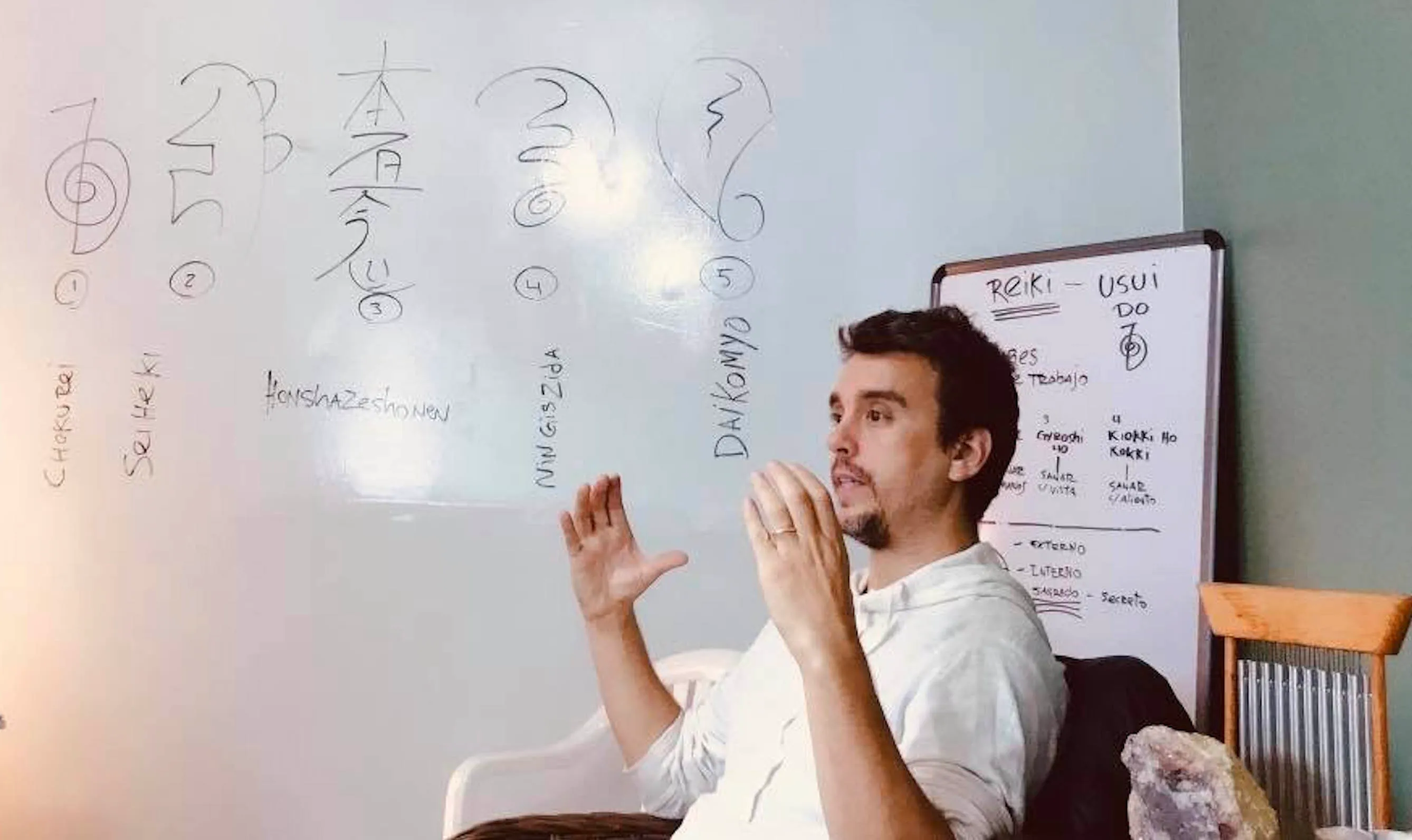 Matías Mahia enseñando los símbolos del Reiki Usui en una clase, pizarra con los kanji y nombres tradicionales